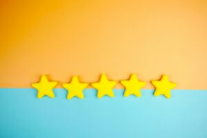 Bright yellow stars arranged on a vivid orange and blue background with copy space.