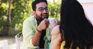 A happy couple sharing coffee and laughter outdoors, capturing love and summertime vibes.